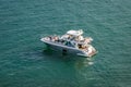 Group of people on pleasure boat hold up Ã¢â¬ÅHAVE FUNÃ¢â¬Â sign and wave to the departing Cruise ships Royalty Free Stock Photo